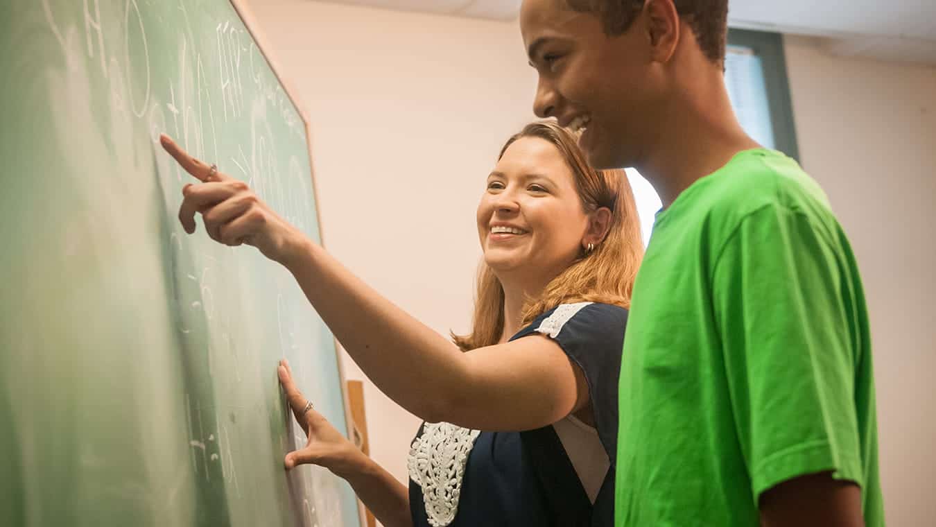 A teacher teaching a student: Pursue an Ed.S. in Educational Leadership – Educational Psychology degree at Regent University.