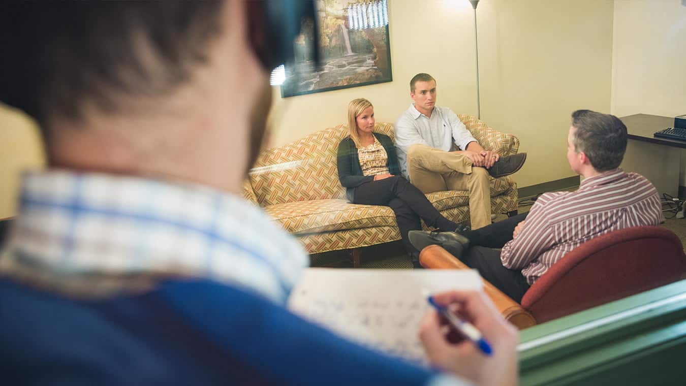 A student observing a couple counseling session: Explore Regent's online MA in Human Services - Marriage and Family Ministry program.