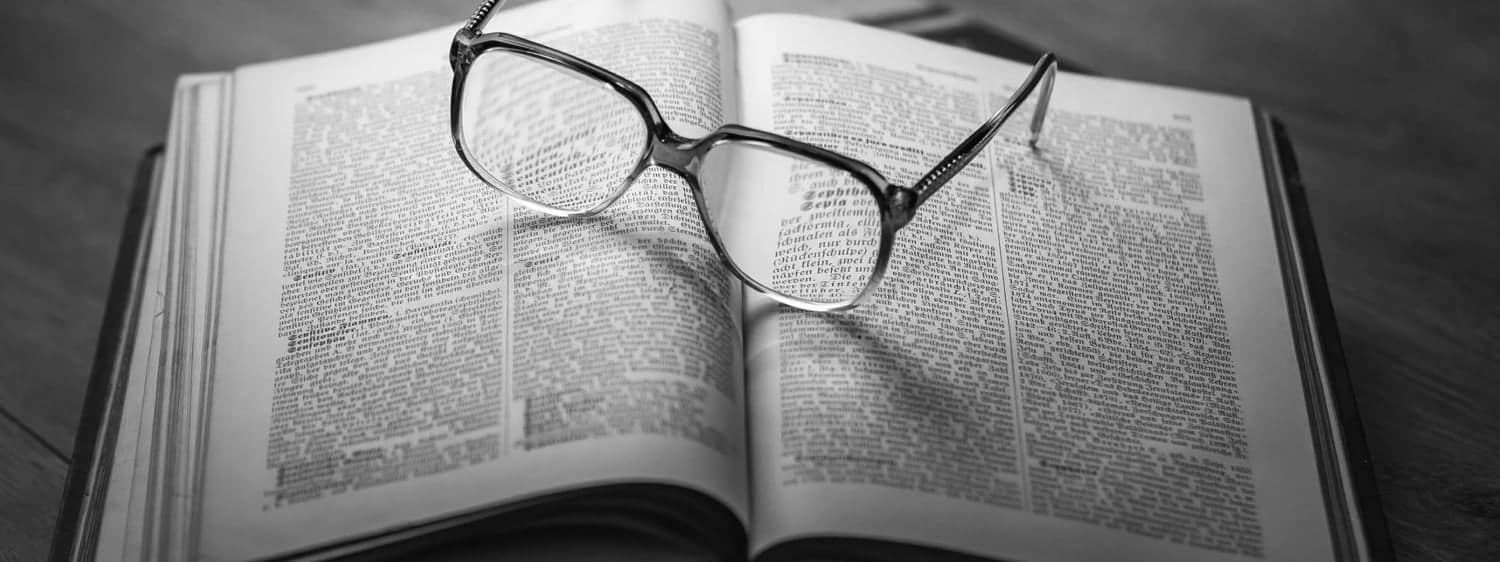 Glasses resting on an open book: Regent University offers a Christian theology certificate program online and in Virginia Beach.