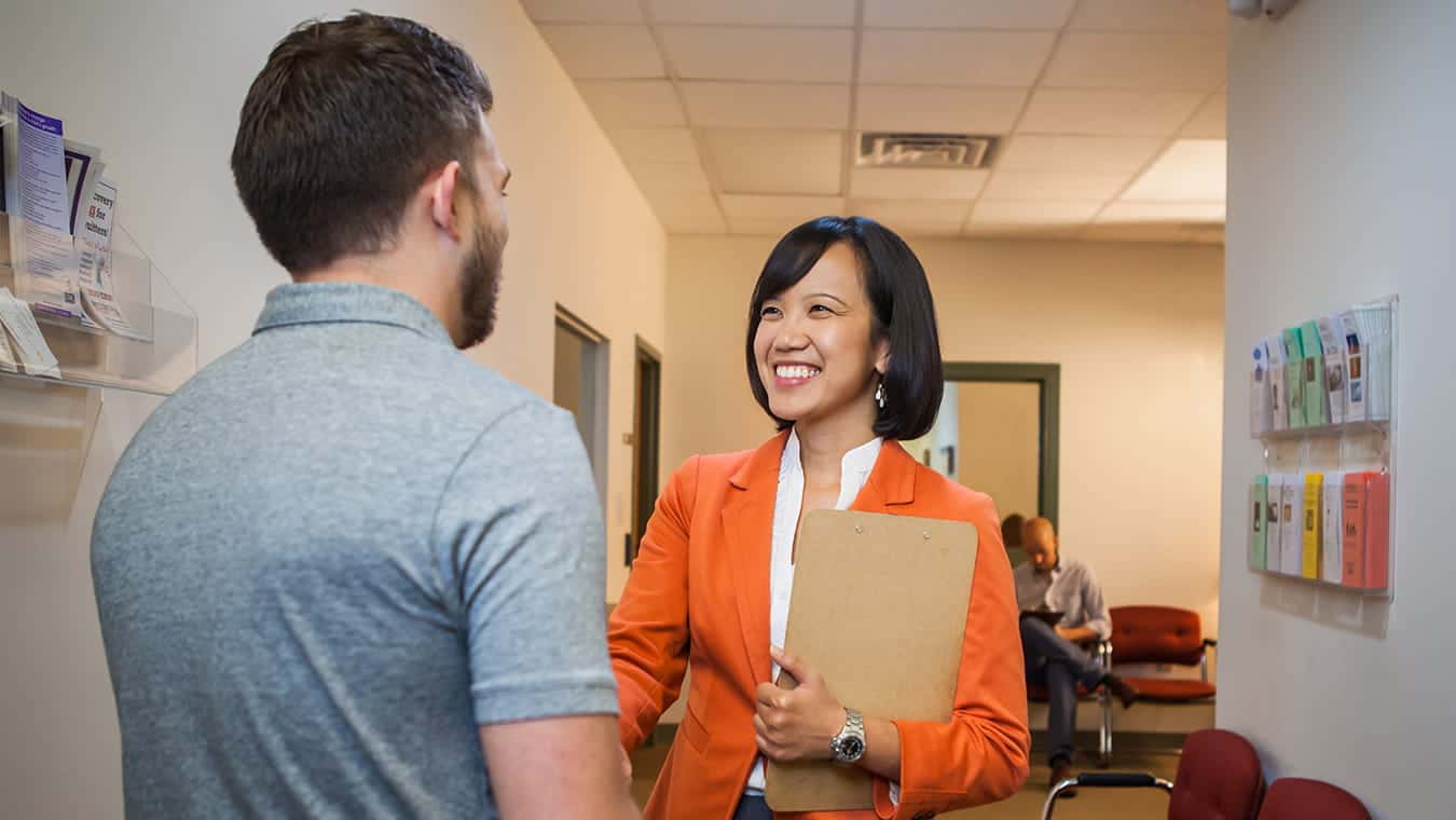 A visitor being greeted: Explore the online CAGS in leadership at Regent University.