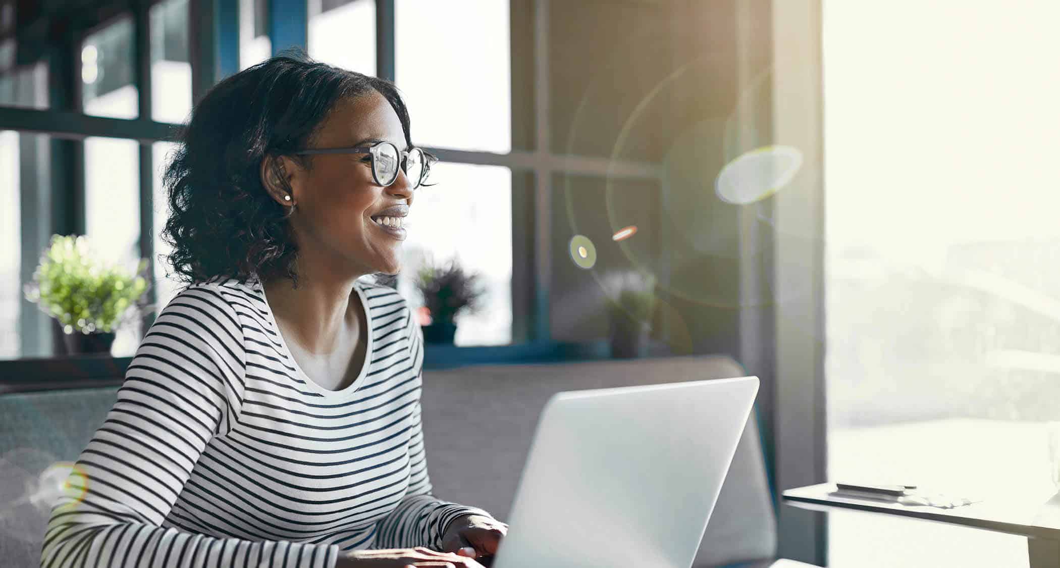 A lady working on her laptop: Explore Regent University's on-campus and online business and leadership degrees,