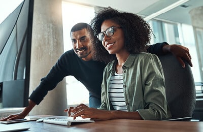 A student with a mentor behind her using the life coaching resources at Regent University, a Christian college in Virginia Beach.