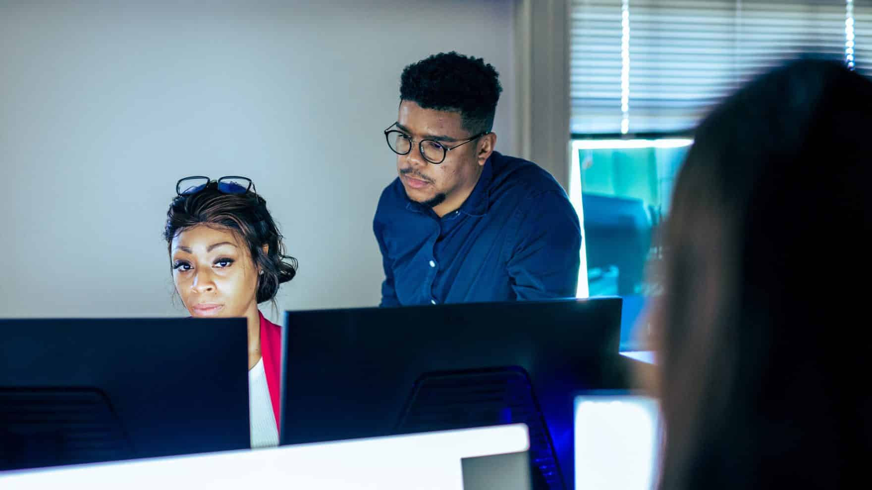 Two students at Regent University in the Certificate of Graduate Studies in Cyber Practitioner Preparation program working together on computers.