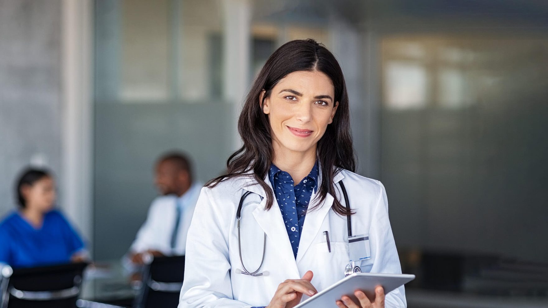 Nurse smiling and looking at a notebook: Explore Regent's DNP advanced practice nursing program.