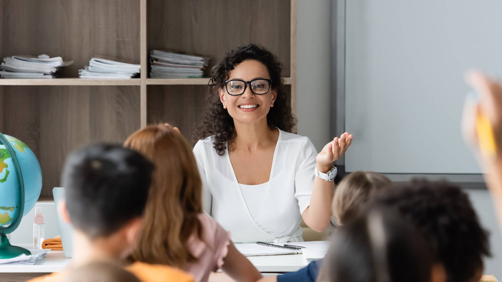 A photo of a teaching the classroom with students: Learn more about Regent's Career Switcher Program.