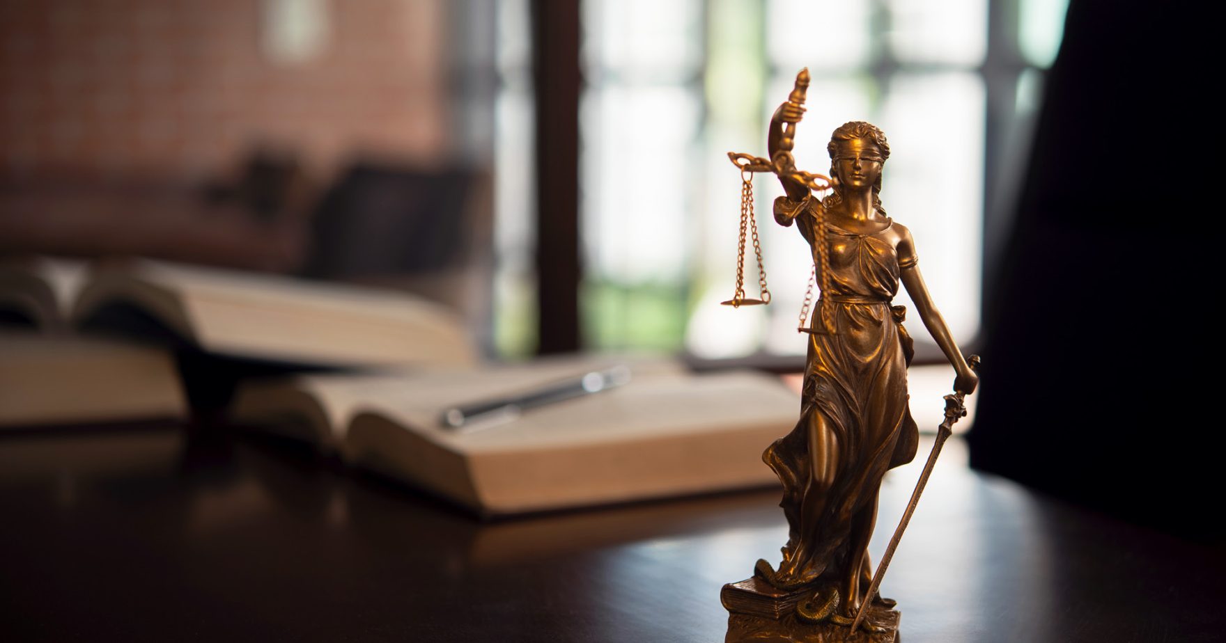 A mini statue of Lady Justice on the desk of a law honors student at Regent University.