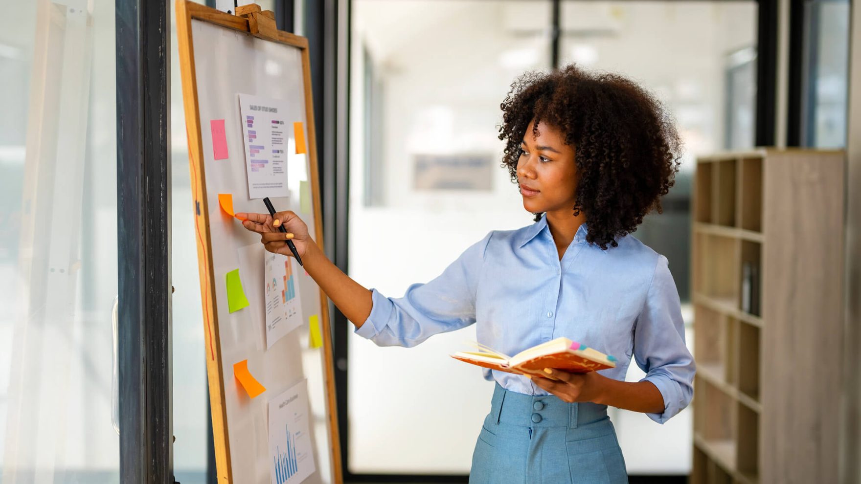 a marketing professional writing on a board.