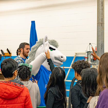 Regent's Rex the Mascot high-fiving students at Brandon Middle School.