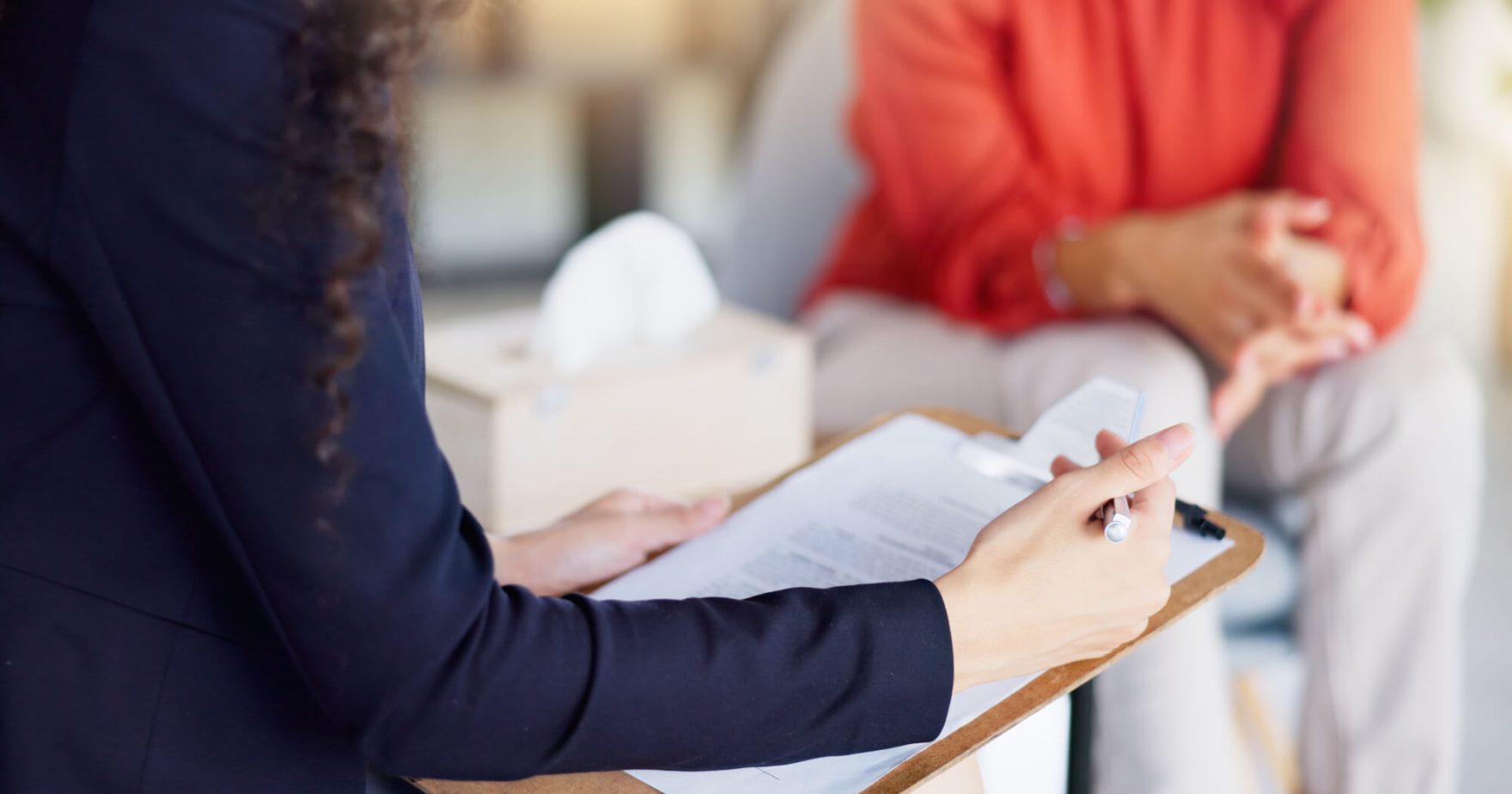 a clinician looking a clipboard and working with a client.